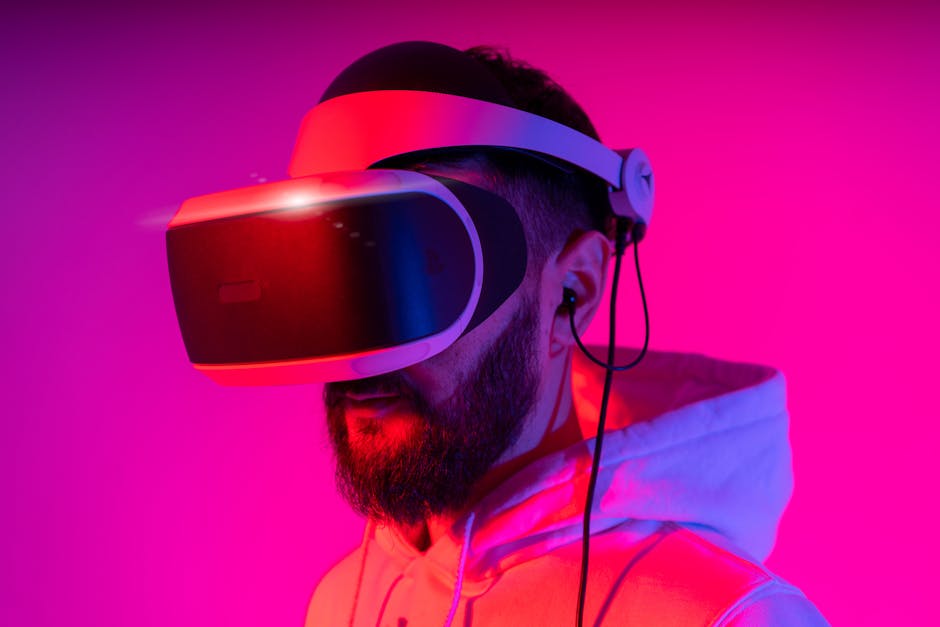 A man wearing a VR headset is immersed in virtual reality, illuminated by vibrant pink lighting.